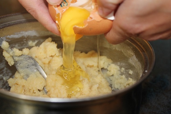 Добавляем яйца в заварное тесто.
